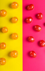 Red and yellow cherry tomatoes on the multicolored geometric background