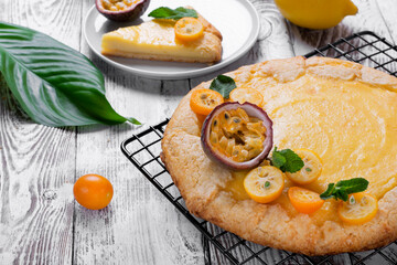 Galette with cottage cheese filling topped with kumquats, passion fruit and mint on the lattice
