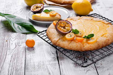Galette with cottage cheese filling topped with kumquats, passion fruit and mint on the lattice