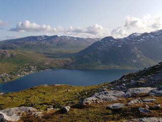 mighty sea and small settlement view from mountain top overlooking kvaloya island in northern Norway in summer
