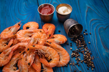 boiled shrimp with pepper and sauces on a blue background