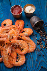 boiled shrimp with pepper and sauces on a blue background