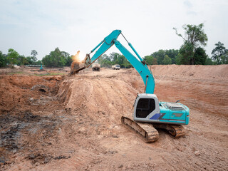 Excavators are digging the soil to make a large pond, which helps to store water.