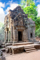 Fototapeta premium Ta Prohm temple (Tomb raider) at Angkor Wat complex, Siem Reap, Cambodia. Ancient Khmer architecture of Angkor Archaeological Park. UNESCO World Heritage site. Noise visible film grain