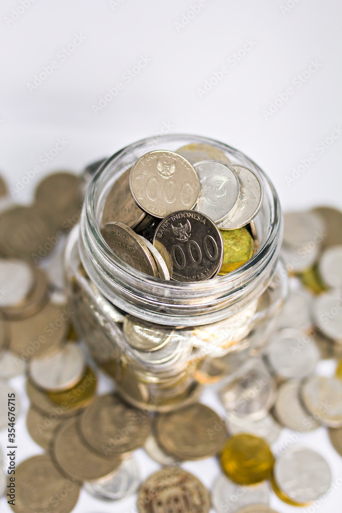 Wall mural various coins money of indonesian rupiah in a jar. concept of investment, saving, and economic