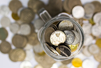 Various coins money of Indonesian rupiah in a jar. Concept of investment, saving, and economic