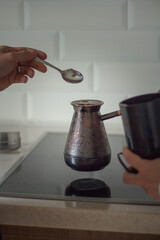 Hand with coffee pot. Joint morning coffee.  Making coffee in Turk. Flavored coffee for loved ones.