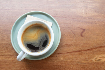Cup of black coffee on wooden table.