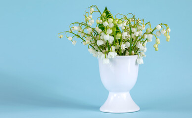 A bouquet of lilies of the valley in an egg stand