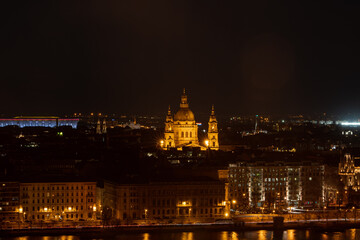 Fototapeta na wymiar Night view of St. Stephenn's Basilica with lights on in Budapest night by Danube river