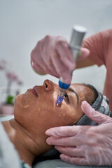 Beauty face skin care. Woman with cosmetic facial mask. Selective focus.