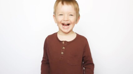 A cute little boy raises his long sleeve shirt and shows the naked belly to the camera