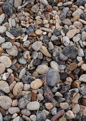 Different texture on the beach - water and sand, stones and pebbles, waves and splashes.