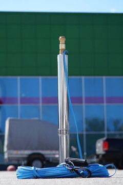 Well pump with cable against the background of the building. Submersible centrifugal pump for wells.