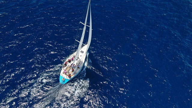 Aerial drone top down photo of beautiful sail boat cruising deep blue Aegean sea © aerial-drone