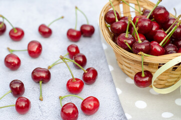 Ripe juicy cherry lies on a table and in a wicker basket. The concept of home gardening.