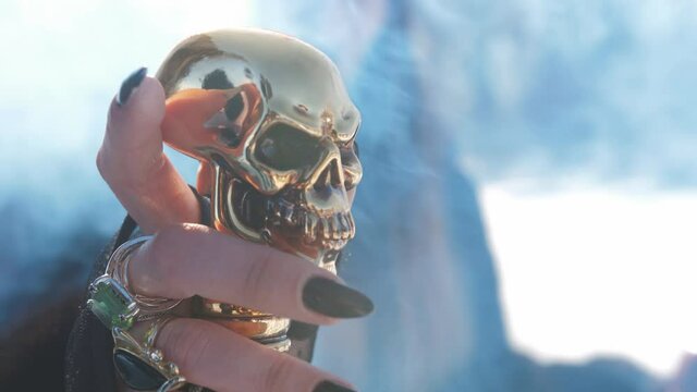 Close-up of hand witches on a cane with a pommel in the form of a Golden skull.