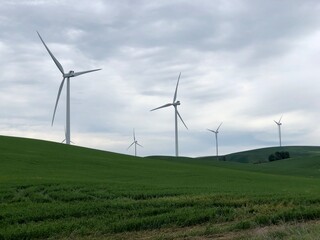 Group of wind turbines spinning on an overcast and cloudy day 