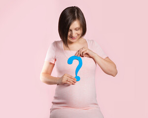 A pregnant woman at 22 weeks of pregnancy. Figure of a pregnant woman in a pink dress on a pink background with a blue question mark. Determining the baby's gender. A boy or a girl.