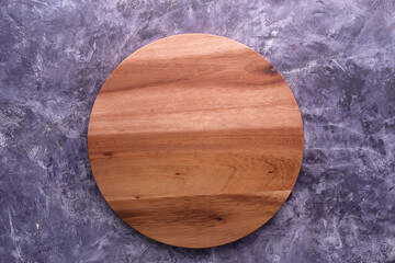 Top view of wooden chopping board on gray background .