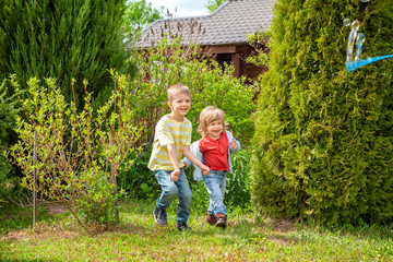 Two European boys play catch-up in the garden. Games in the fresh air.