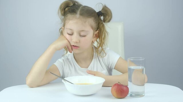 school little girl falls asleep at Breakfast, did not go to bed for a long time