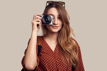 Smiling student hipster girl with backpack and camera going on a vacation