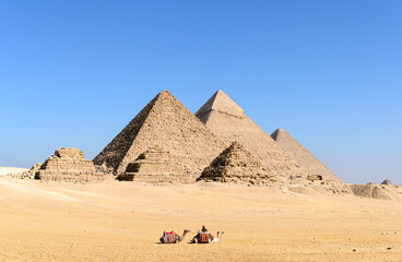 The great Pyramid complex of Giza with two camel caravan sitting in front of the Egyptian pyramids-...