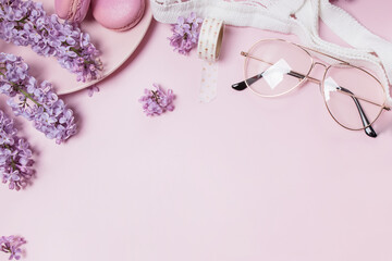 Spring flat lay with lilac flowers, glasses and macarons