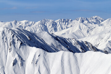 High snowy mountains and blue sky with clouds