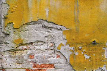 Detail of a distressed and weathered yellow brick wall with render in Venice, Italy. cool background or texture for your poster idea.