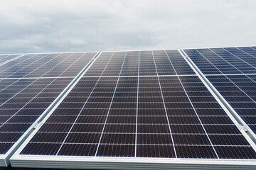 Obraz premium Solar panels stands in row on the ground . Free electricity for home. Sustainability of planet. Green energy. Solar cells power plant business. Ecological clean energy. Blue panels on the ground.