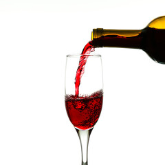 Fototapeta na wymiar red wine is pouring into a glass from a bottle on white background