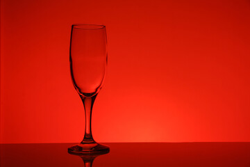 empty transparent wine glass on red background
