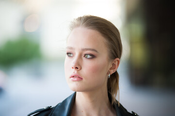 Obraz premium Beautiful young blonde woman in a leather jacket outside