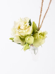 A bouquet of white roses in a small hanging vase for a wedding