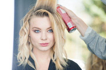 Naklejka premium Professional makeup for a woman in a beauty studio