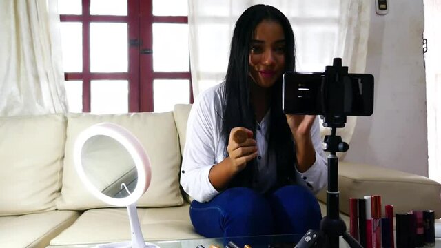 Beautiful young influential woman shooting makeup video tutorial. Fashion concept