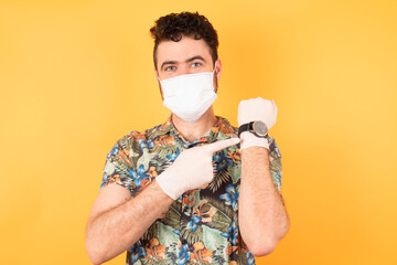 Young handsome caucasian businessman with short hair wearing hawaiian shirt and medical mask, In...