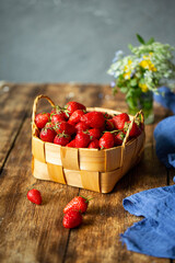 In a basket strawberry on a wooden table. place for text.
