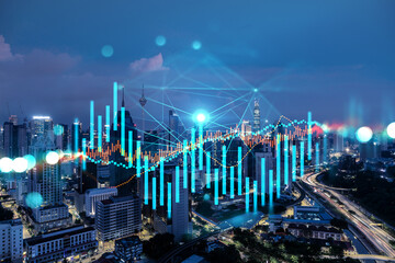 FOREX graph hologram, aerial night panoramic cityscape of Kuala Lumpur. KL is the developed...