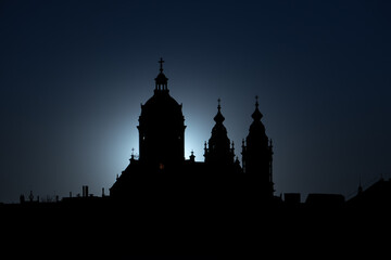 Neo-Baroque Basilica of Saint Nicholas silhouette at the sunset against orange sky with a sun setting behind in Amsterdam