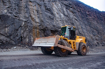 mountain loader in an iron ore quarry. Mining loader. Mountain loader on the background of the side of the quarry