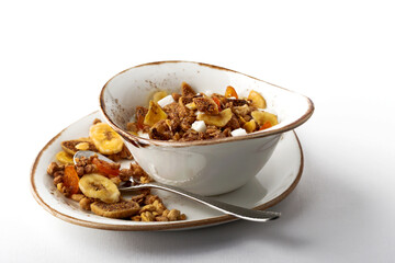 Authentic muesli and a cup of tea sprinkled with cinnamon on a white tablecloth. Morning atmospheric lighting, fashionable trendy spot soft focus. Preparation for design creative menu.