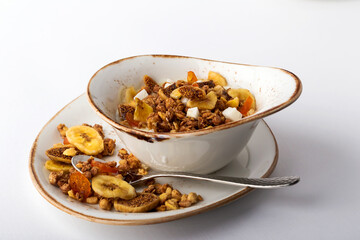 Authentic muesli and a cup of tea sprinkled with cinnamon on a white tablecloth. Morning atmospheric lighting, fashionable trendy spot soft focus. Preparation for design creative menu.