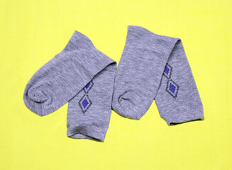 Grey men's socks on a yellow background