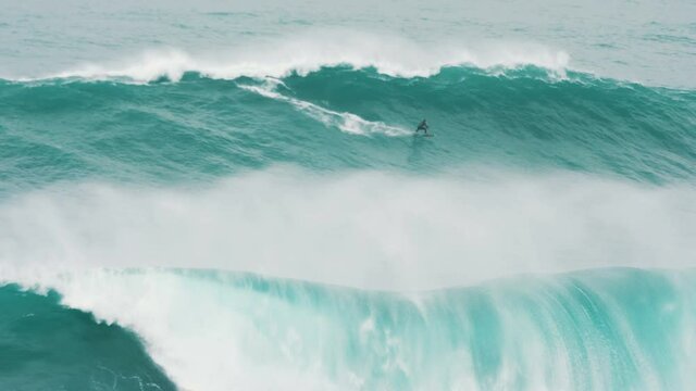 professional surfer rides a giant wave on a surf, slow motion