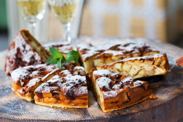 Authentic sponge cake with raisins, cinnamon and apples. Morning atmospheric lighting, fashionable trendy spot soft focus. Preparation for design creative menu. Culinary pastries.