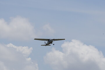 Fototapeta na wymiar Prop airplane flying amongst a cloud backdrop