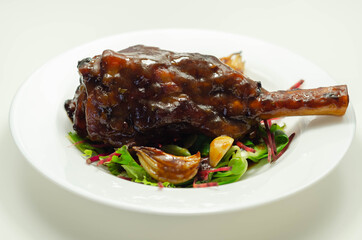 Delicious Lamb shank with red wine and rosemary gravy served on the mixed leaf salad